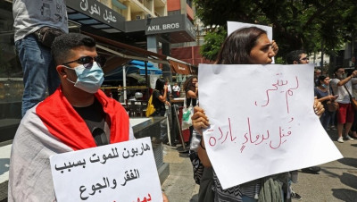 لبنانيون يضعون الزهور في شارع شهد انتحار رجل بطريقة مأساوية